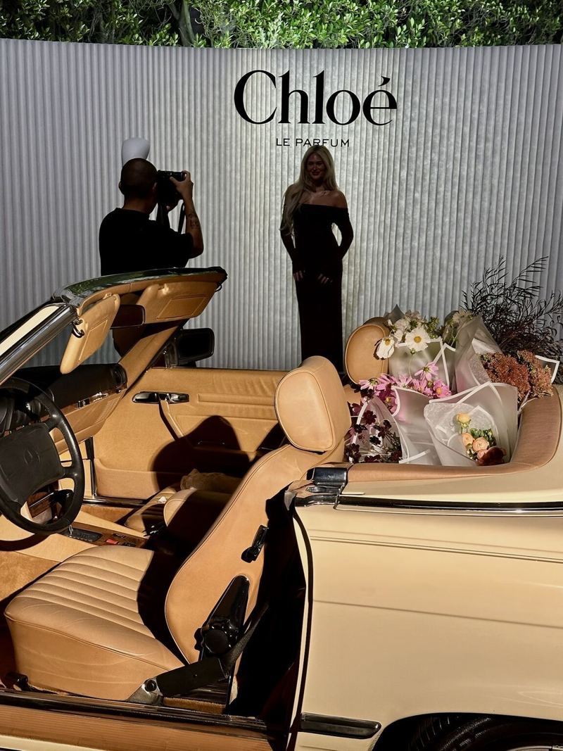 Vintage convertible in front of the Chloé wall, with a photographer, at the fragrance activation